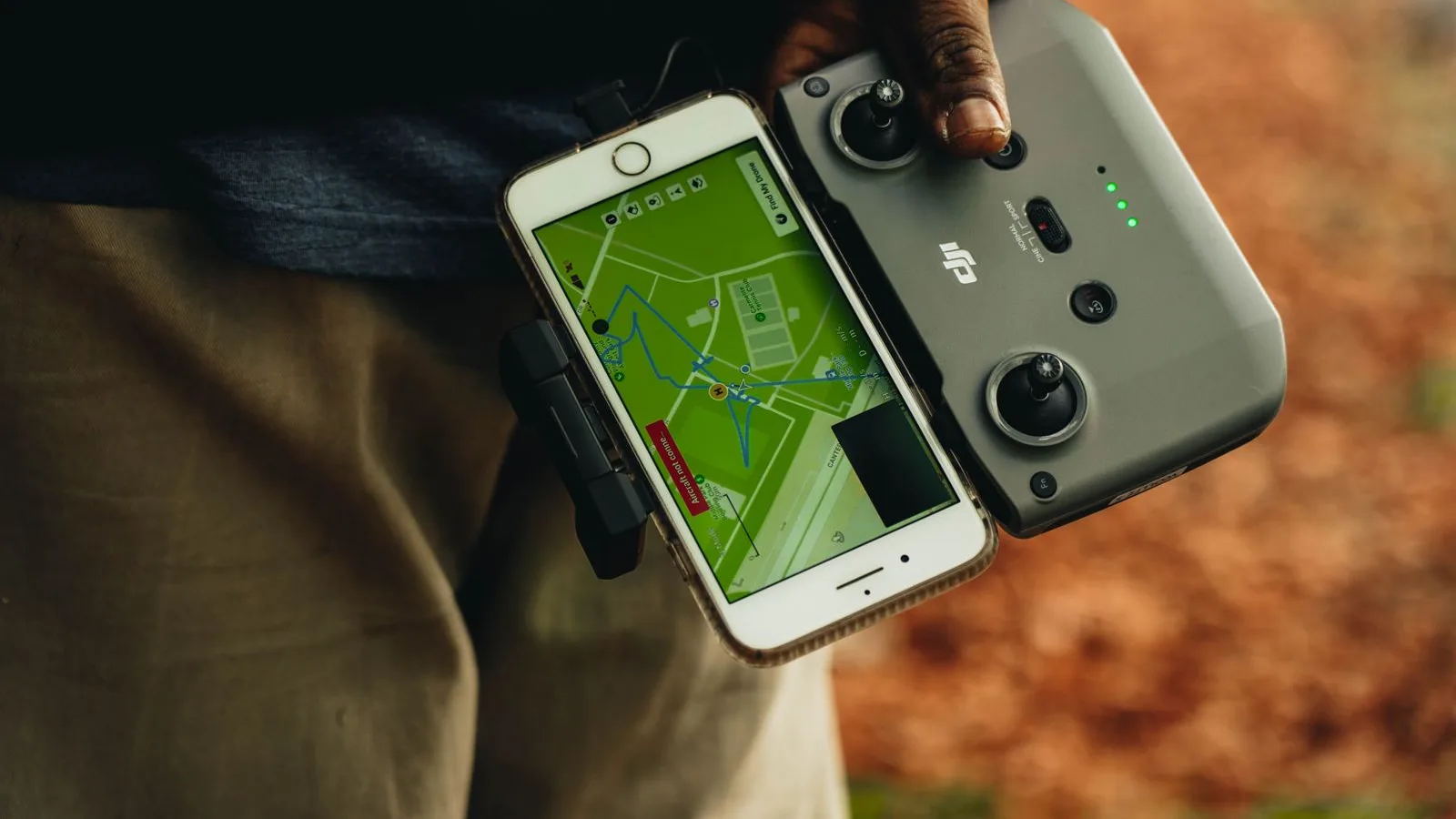 Persona operando el control de un dron con un mapa en el teléfono